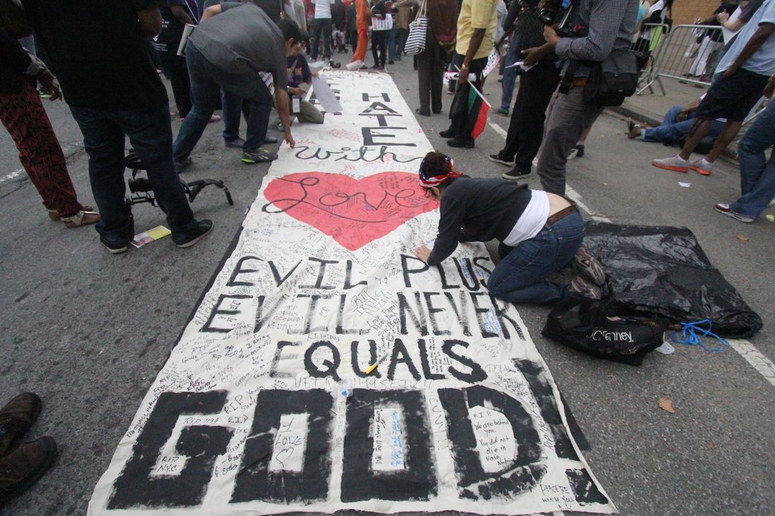Protestors took turns writing their own messages on a banner at the rally.